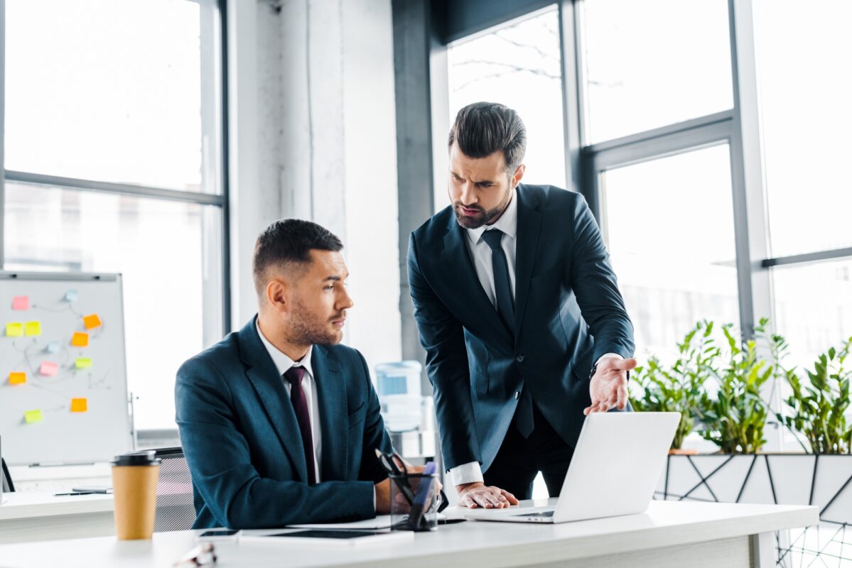 handsome businessman having discussion with coworker in modern office