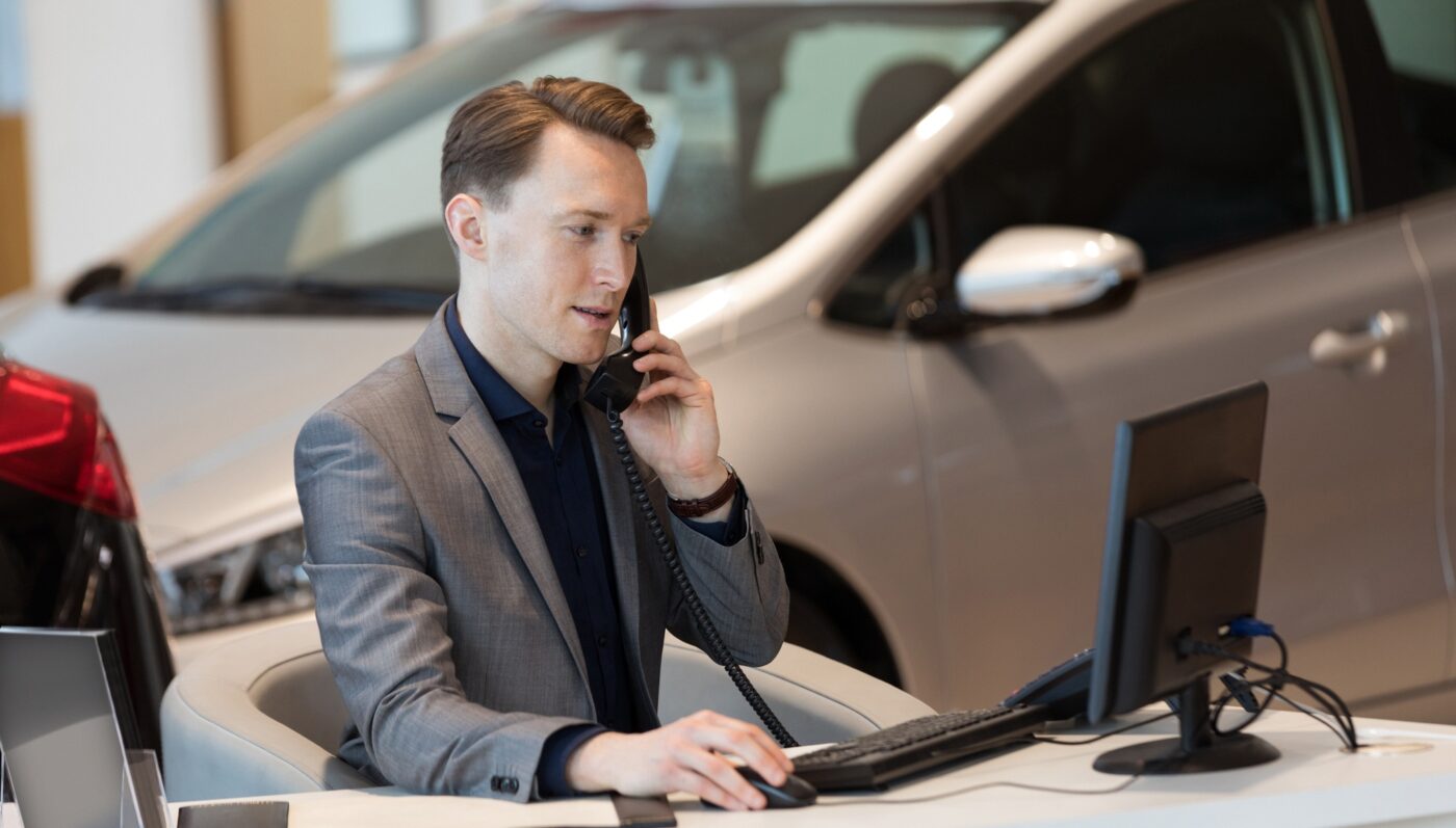 Sales talking on phone while using computer